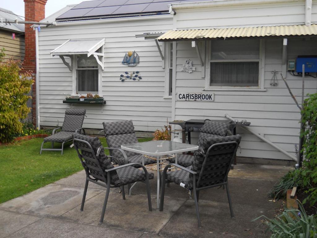 a table and chairs in front of a house at Carisbrook Cottage Queenscliff in Queenscliff