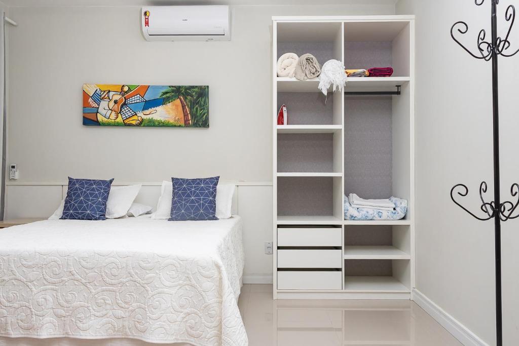 1 dormitorio con cama y estante para libros en Brasil Buzios, en Búzios