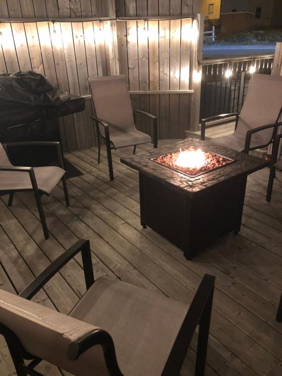 a fire pit on a patio with chairs and a table at Alma’s Cape Shore Cottage! Your home away from home! in Bonavista