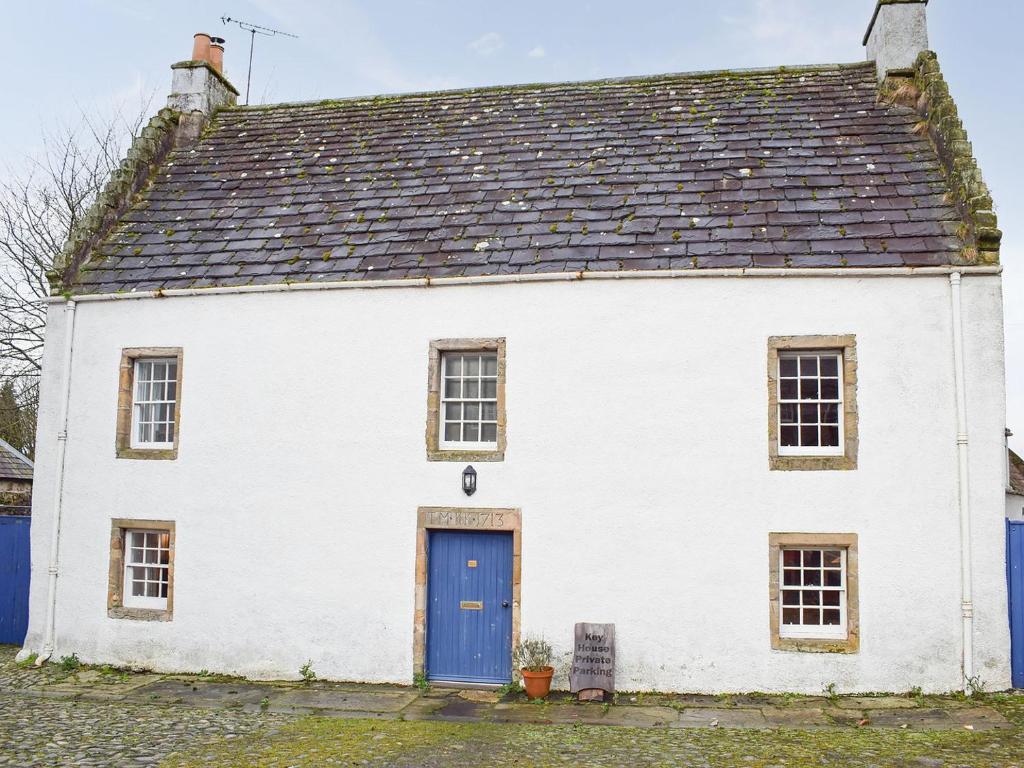 a white house with a blue door at Key House in Falkland