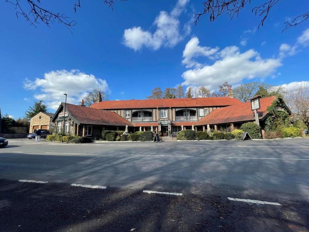 布萊克本的住宿－The Ribchester Arms，街道上一座红色屋顶的大型建筑