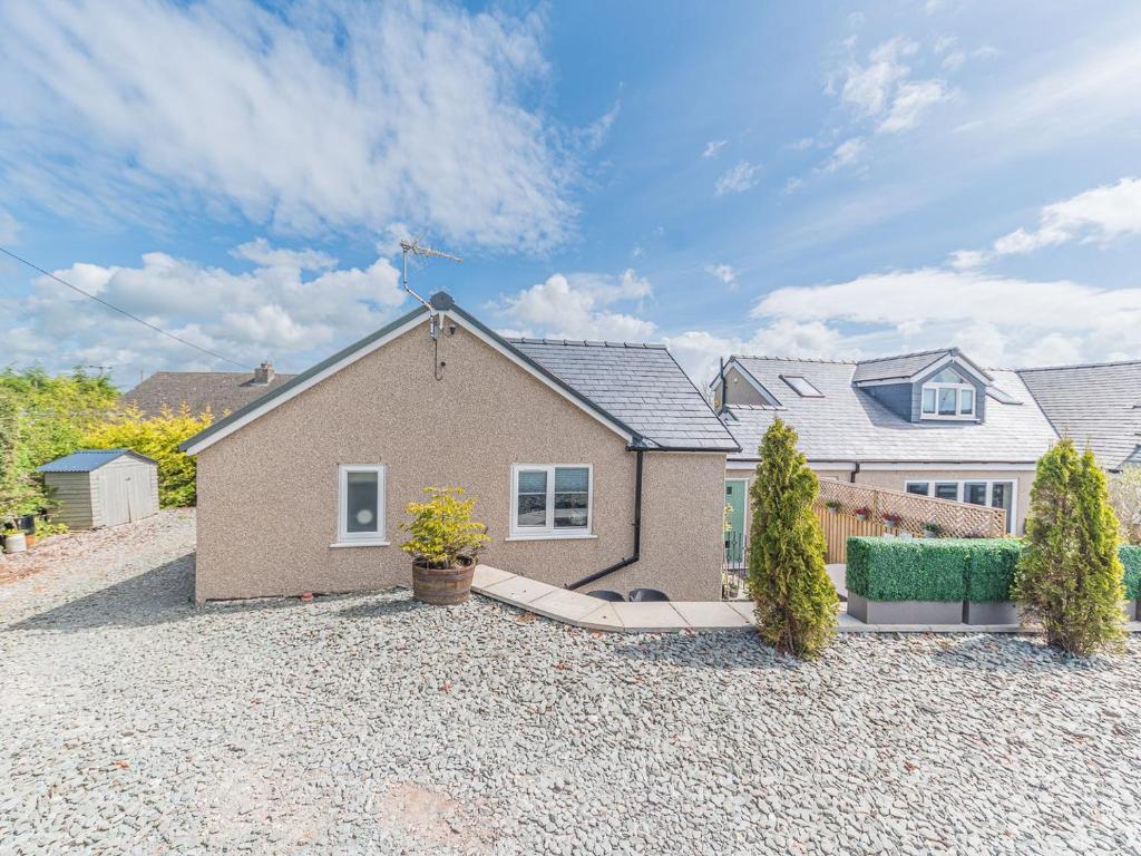 a house with a gravel driveway in front of it at The Lodge in Dalton in Furness