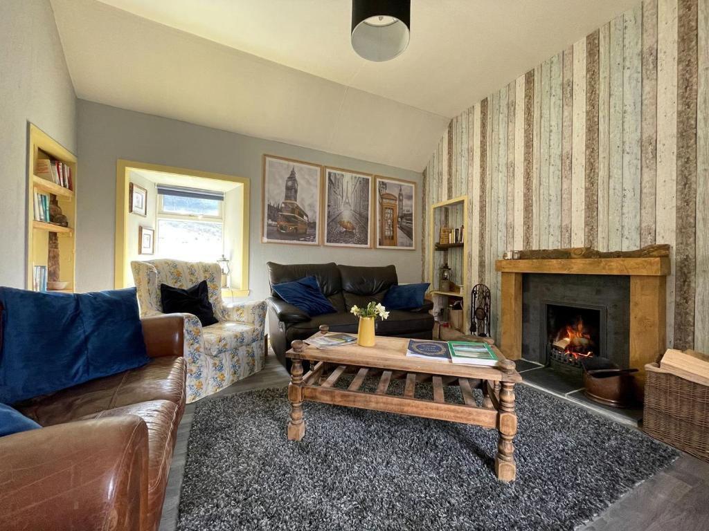 a living room with a couch and a fireplace at Sheenas Butnben in Arnisdale