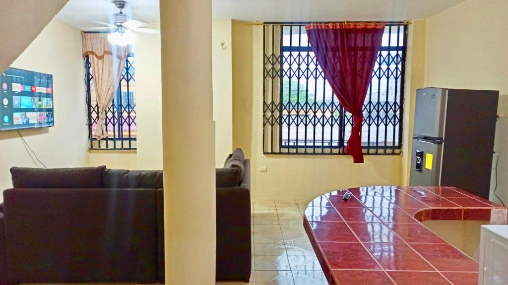 ein Wohnzimmer mit einem Sofa und Buntglasfenstern in der Unterkunft Departamento la comodidad de tu casa in Machala