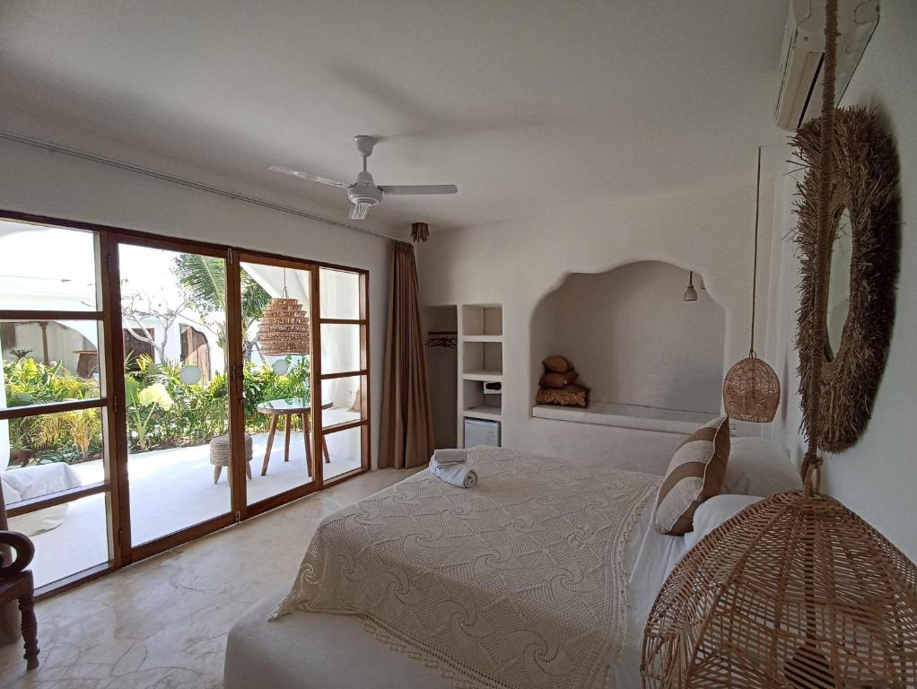 a bedroom with a bed and a large window at Sal Central in Uluwatu