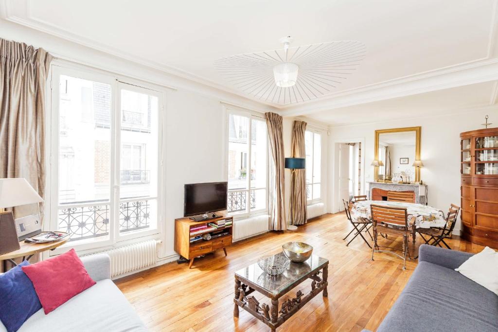 sala de estar con sofá y TV en Large Apartment For A Family 2 Adults Max! en París