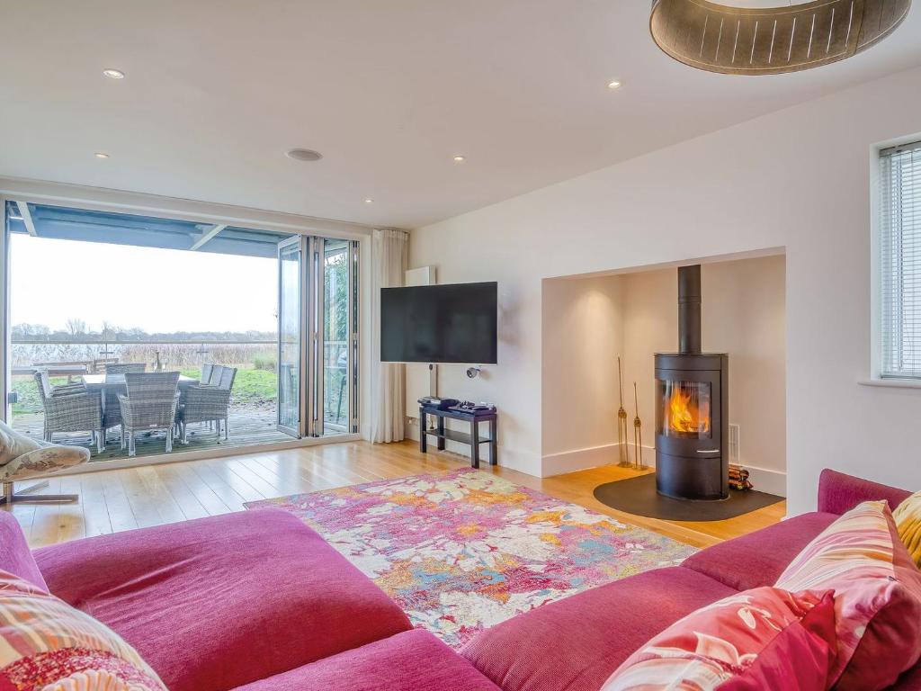 a living room with a couch and a fireplace at Otters View in Somerford Keynes