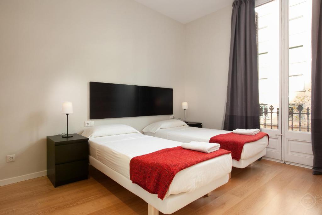 バルセロナにあるModern Center Apartmentsのベッドルーム1室(ベッド2台、大きな窓付)