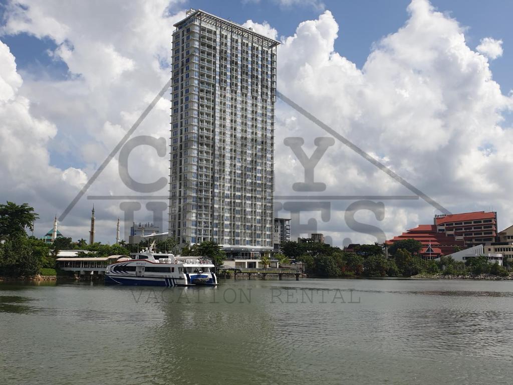 a tall building with a boat in the water at CozyHomes at One Residence Batam in Batam Center
