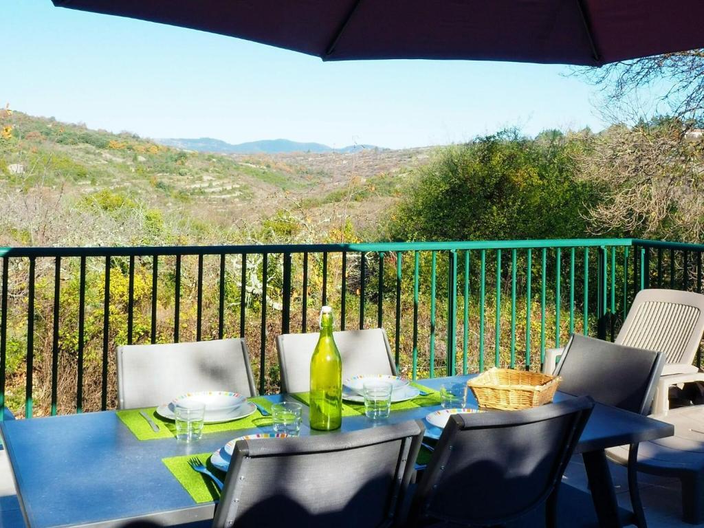 una mesa azul con sillas y una botella de vino en Holiday home, Villemagne-l'Argentière, en Villemagne