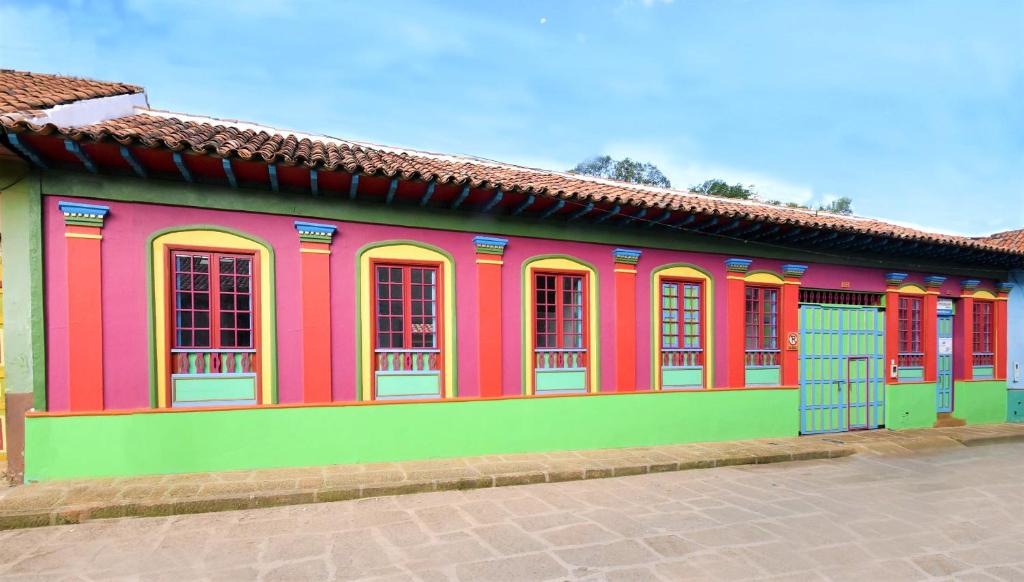 a brightly colored building with red and green at Casona 1865 in Ráquira