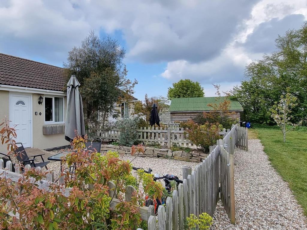un jardín con una valla blanca y una casa en Widgeon Cottage - Uk33873, en Cote