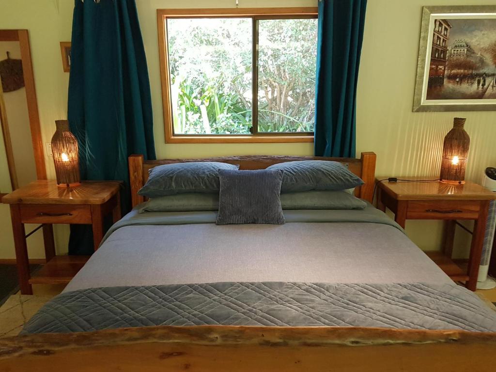 a bedroom with a bed with a window and two lamps at Garden Studio in Jaggan