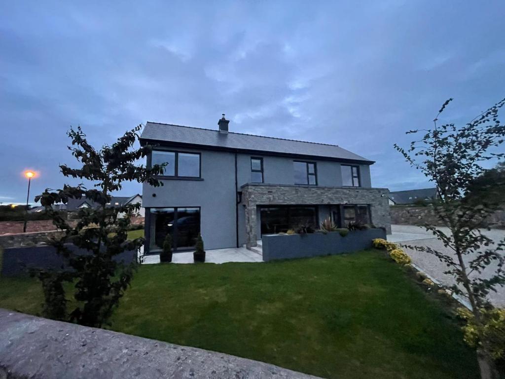 una gran casa blanca con un patio de césped en Exquisite Galway City Luxury home – Sleeps 10, en Galway