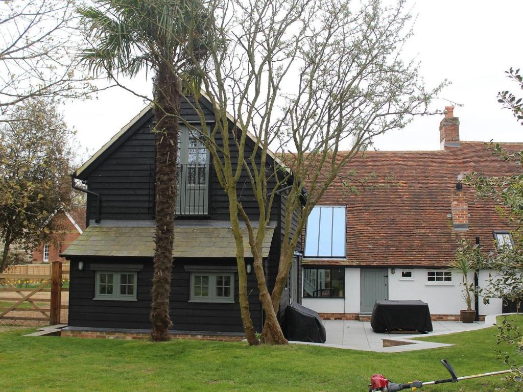 uma casa preta com um telhado de gambrel em Oasis em Bradwell on Sea