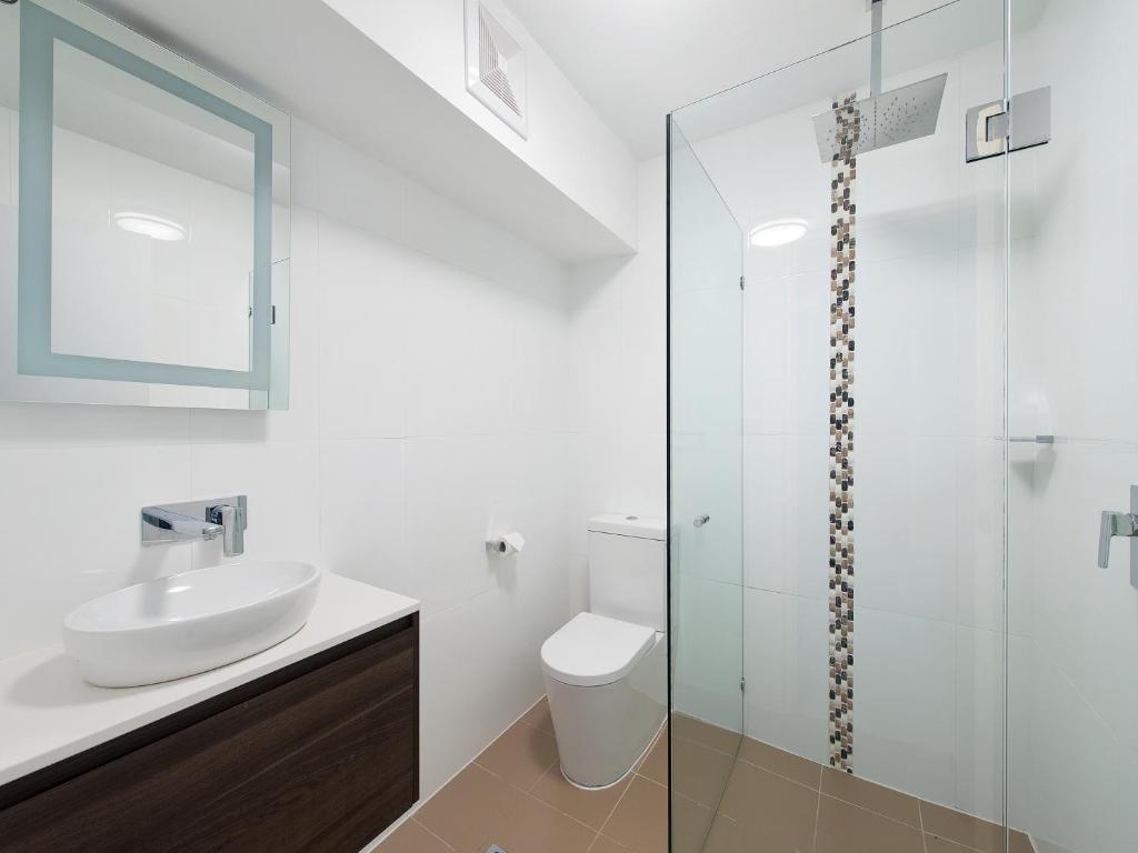 a bathroom with a sink and a glass shower at Belle by the Bay in Fingal Bay