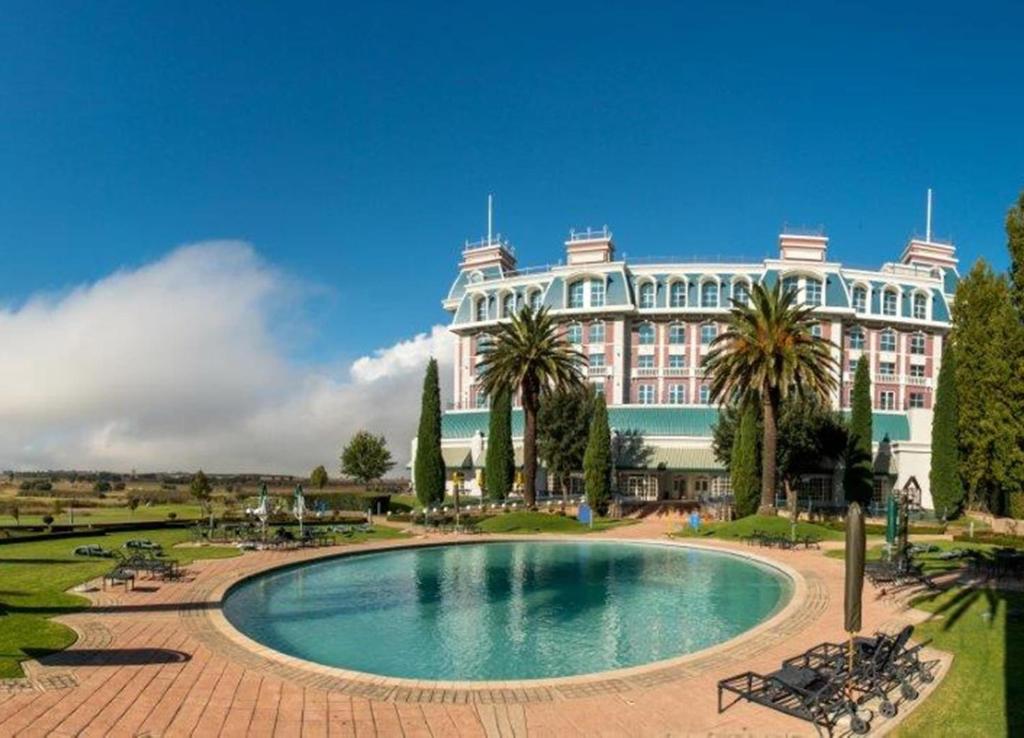 ein großes Gebäude mit Pool davor in der Unterkunft Walmont at Graceland in Secunda