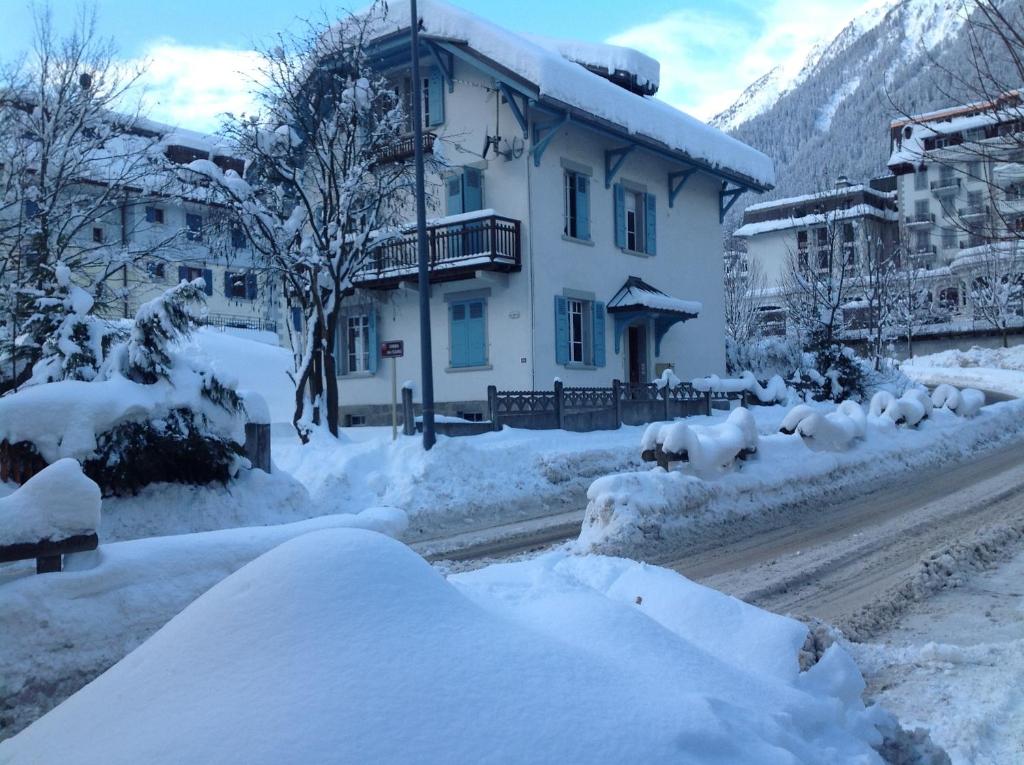 a snow covered street with a house and buildings at La Brise in Chamonix