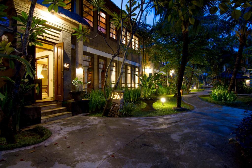 a building with lights on the side of it at night at Desamuda Village in Seminyak