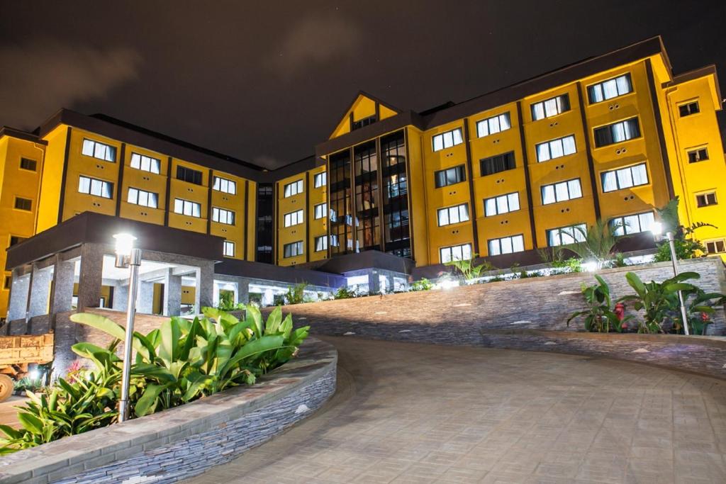 a row of yellow buildings at night at Grand Legacy Hotel in Kigali