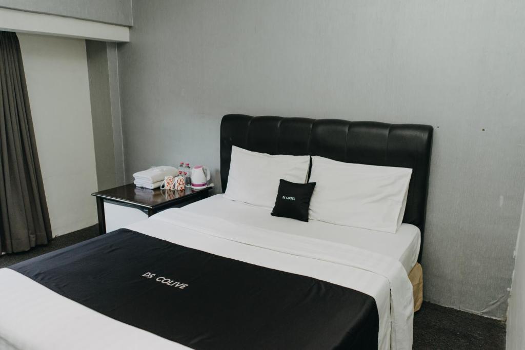 a bed with a black headboard in a hotel room at DS Colive 34 in Semarang