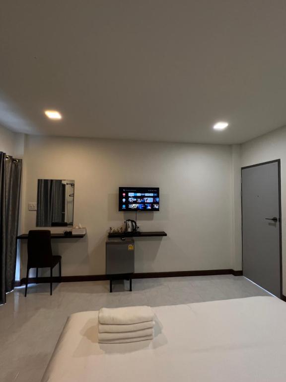 um quarto com uma televisão de ecrã plano na parede em see-on place/สีอ่อนเพลส em Ban Tha Phae