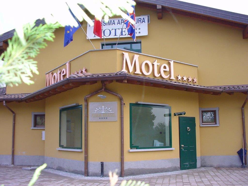 a building with a motel sign on top of it at Hotel Adda in Spino dʼAdda