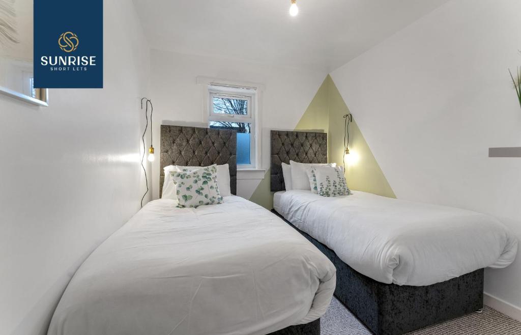 2 camas en una habitación con paredes blancas en 3 BED LAW, 3 rooms, 1 Bathroom, Free Parking, WiFi, Sleeps 4, Contractors, Tourists, Relocation, Business, Travellers, Short - Long Stay Rates Available by SUNRISE SHORT LETS, en Dundee