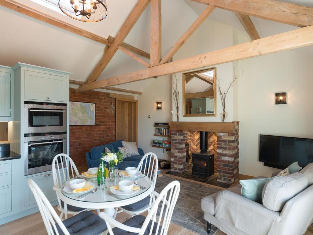 a kitchen and living room with a table and chairs at Daisy in Scruton
