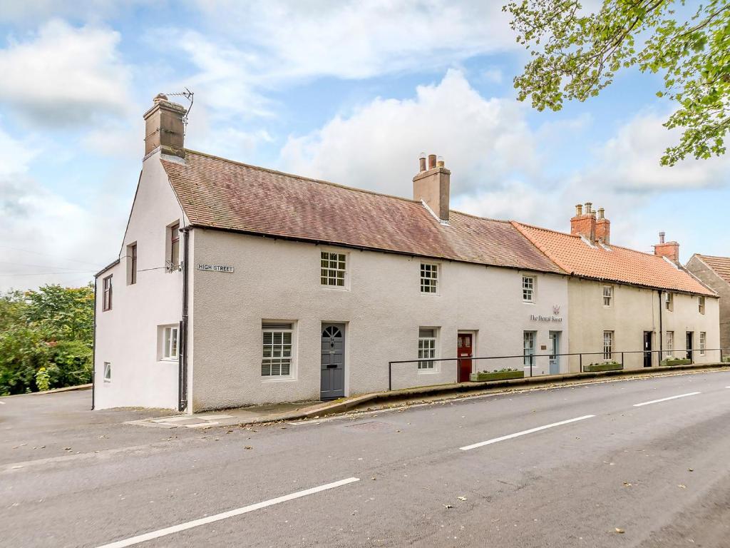 un viejo edificio blanco al lado de una carretera en Millers Cottage en Belford