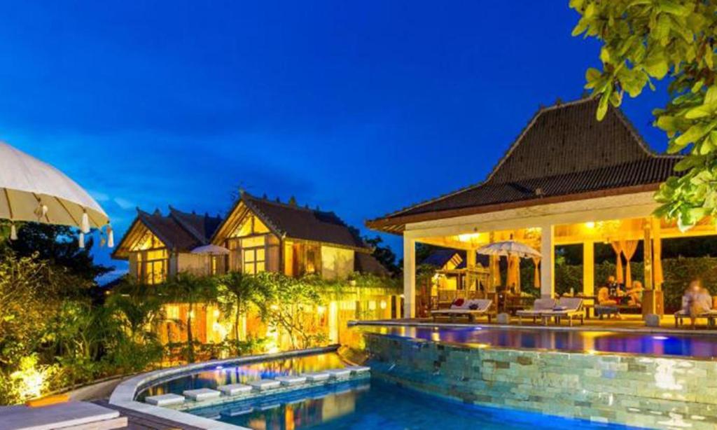 a villa with a swimming pool at night at BoHo Bingin Beach Bali in Uluwatu