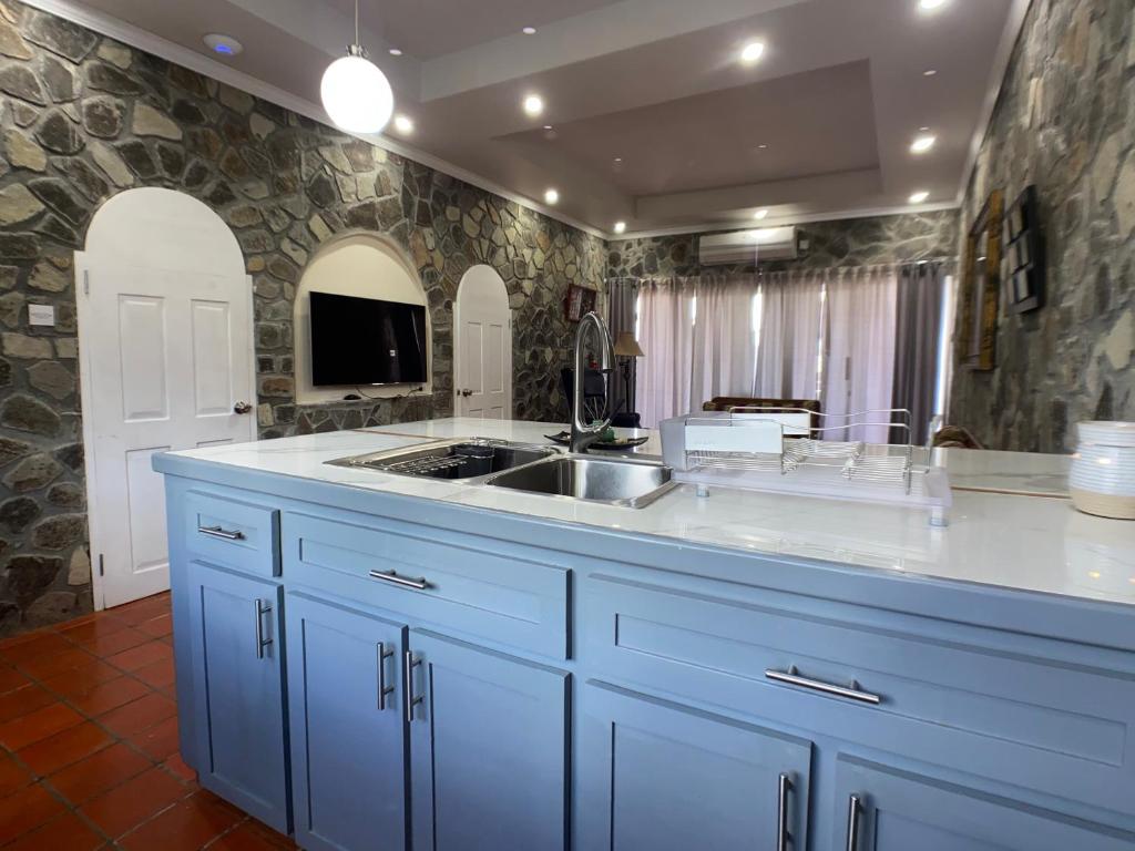 una cocina con armarios azules y fregadero en Stonetrail Villas, en Arnos Vale