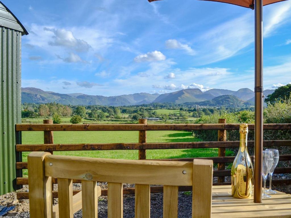 a wooden bench on a deck with a view of mountains at Skiddaw - Uk1354 in Applethwaite