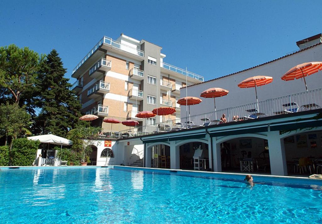 une grande piscine avec des parasols en face de l'hôtel dans l'établissement Hotel Nautic B&B, à Bellaria-Igea Marina