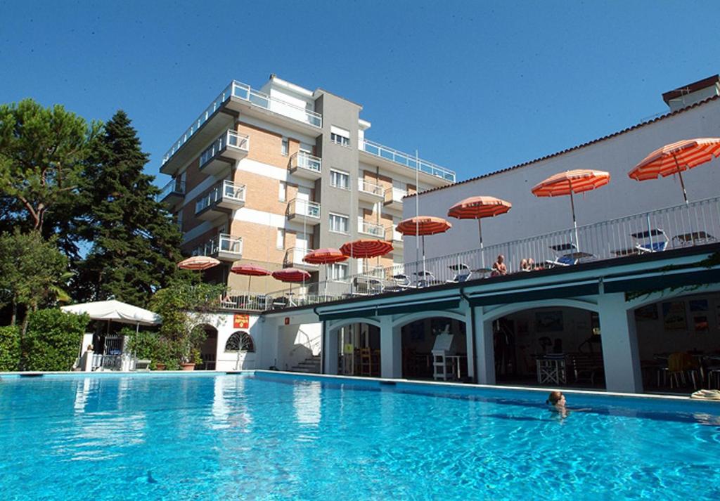 una grande piscina con ombrelloni di fronte a un hotel di Hotel Nautic B&B a Bellaria-Igea Marina