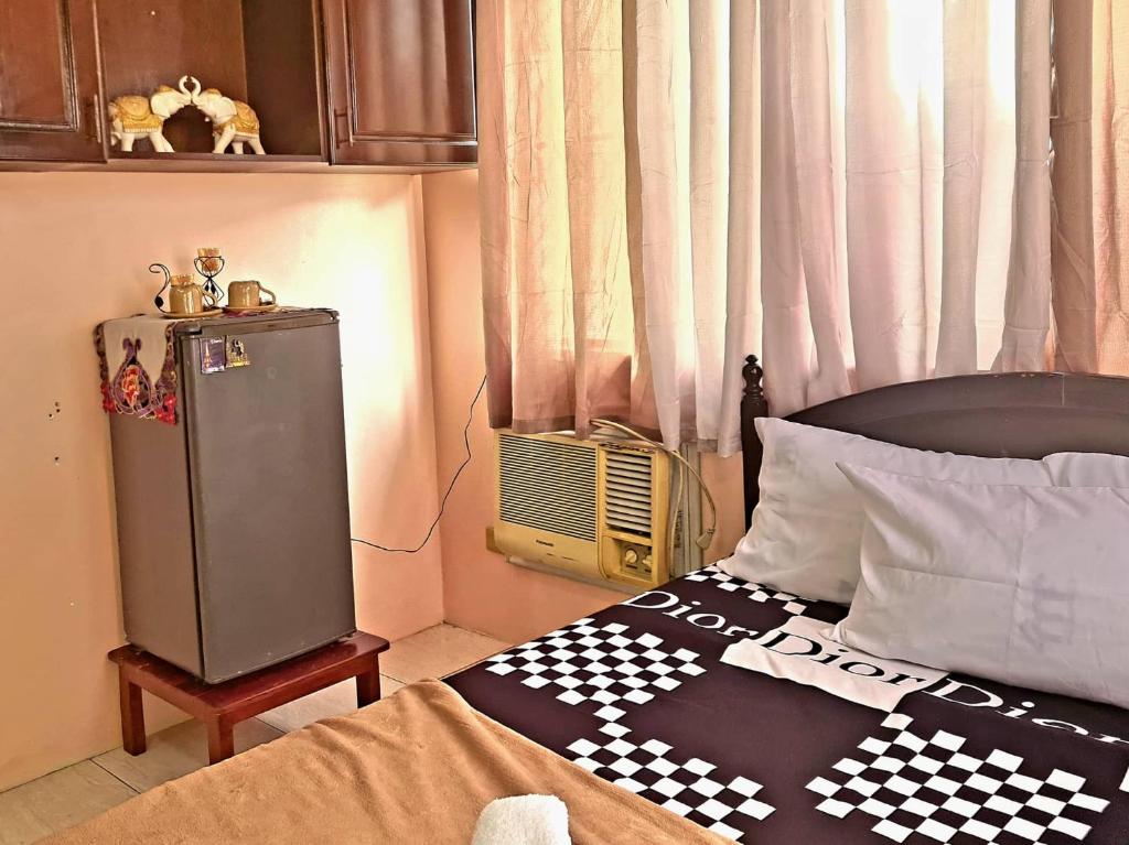 - une chambre avec une couverture en damier sur un lit dans l'établissement Affordable Condo for Rent near Emperor Events Place, à Cainta