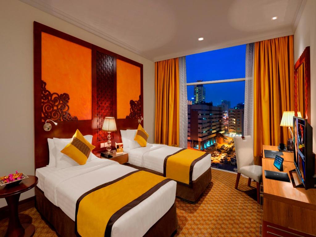 a hotel room with two beds and a window at Landmark Premier Hotel in Dubai