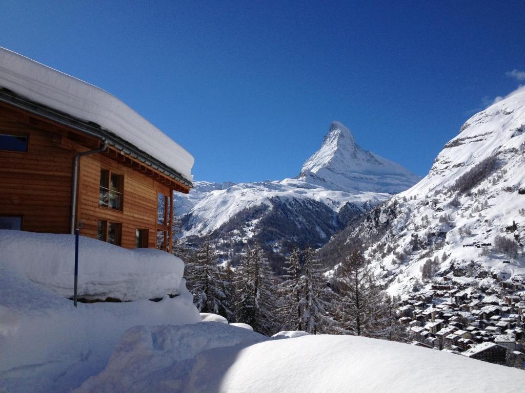 a snow covered mountain in front of a building at Chalet Arnold in Zermatt
