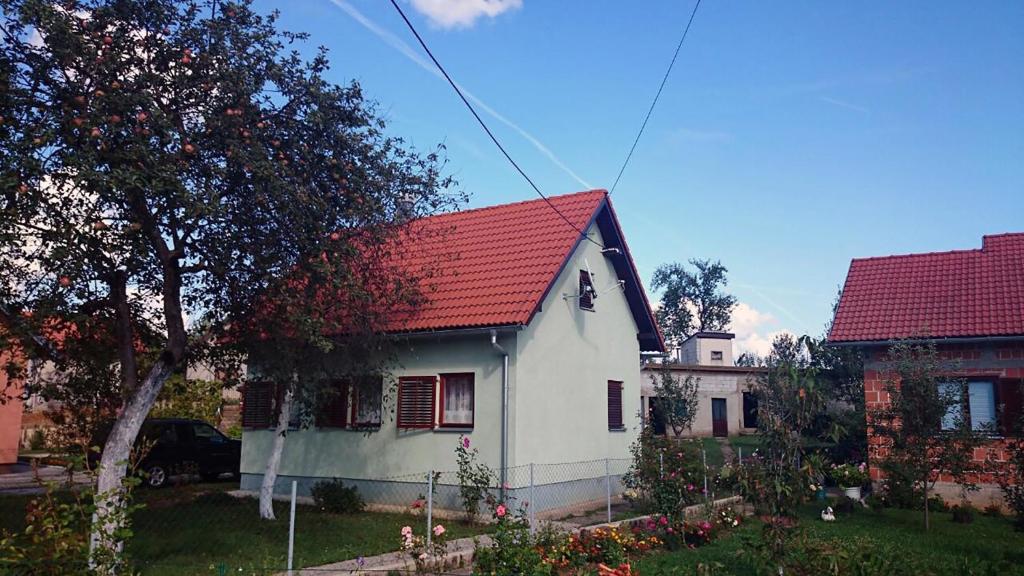 ein kleines weißes Haus mit rotem Dach in der Unterkunft Bakina kućica - Grandma's cottage in Gospić