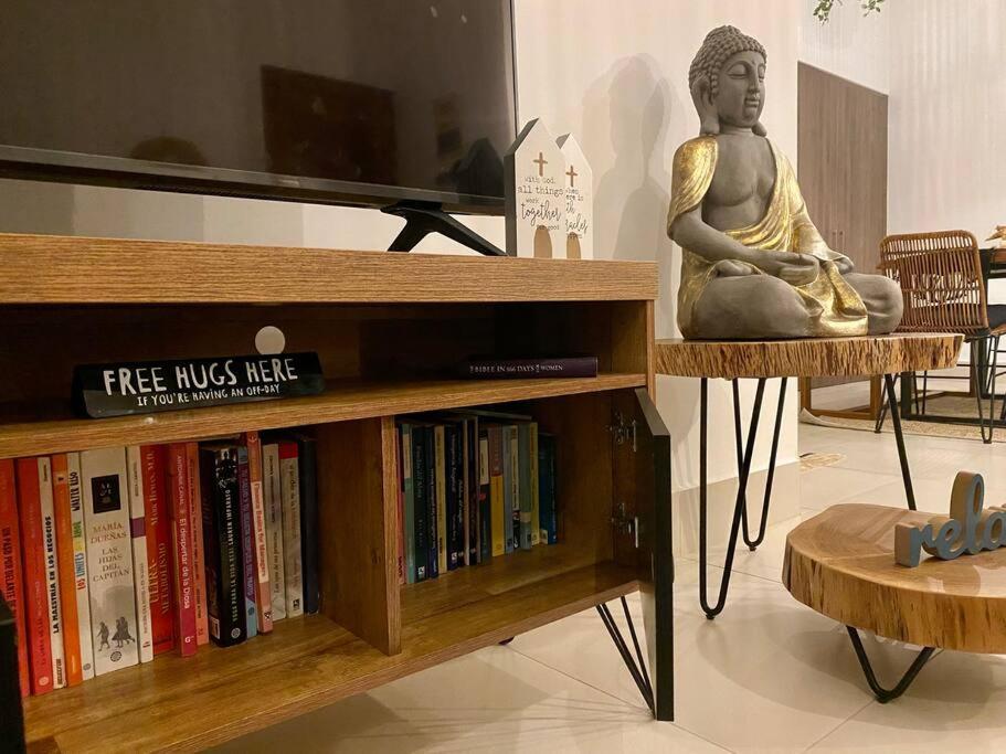 Charming Zen-style Beach apartment at Punta Caelo في سان كارلوس: تمثال لامرأة جالسة على رف كتاب