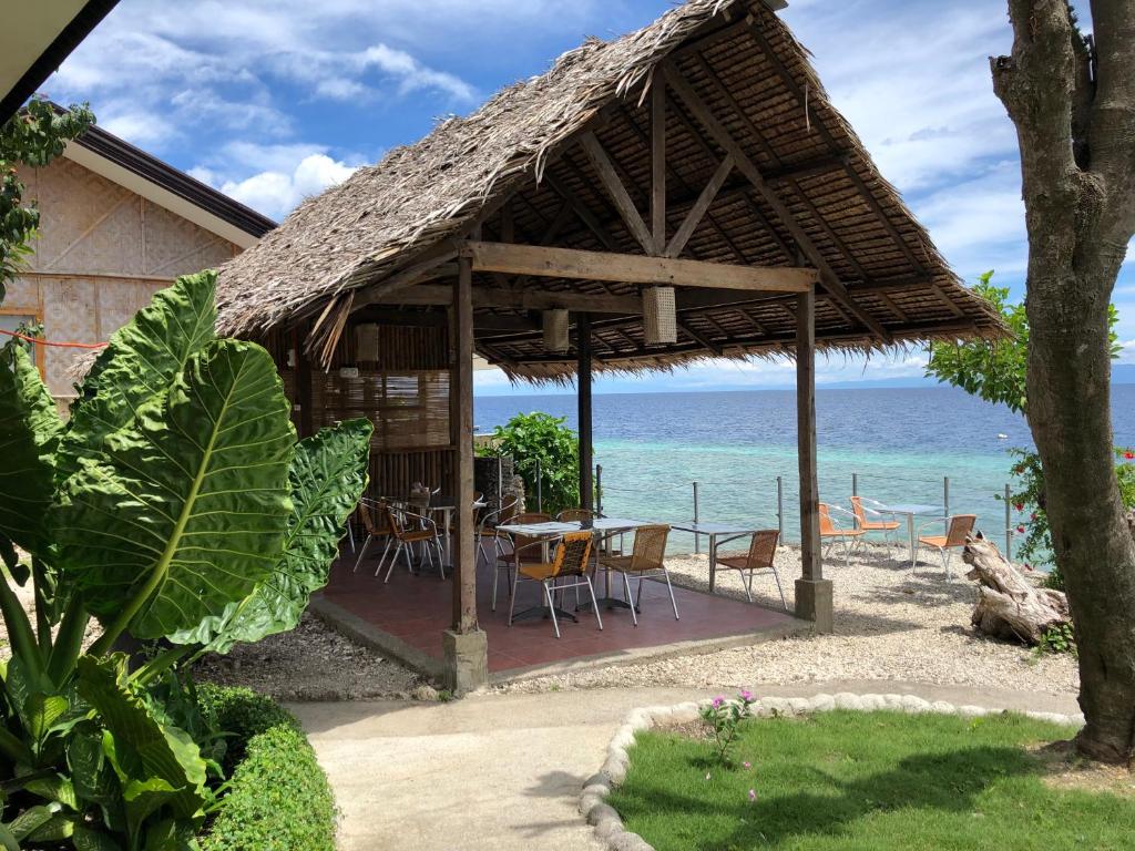 una capanna con tavolo e sedie sulla spiaggia di Tipolo Beach Resort a Moalboal