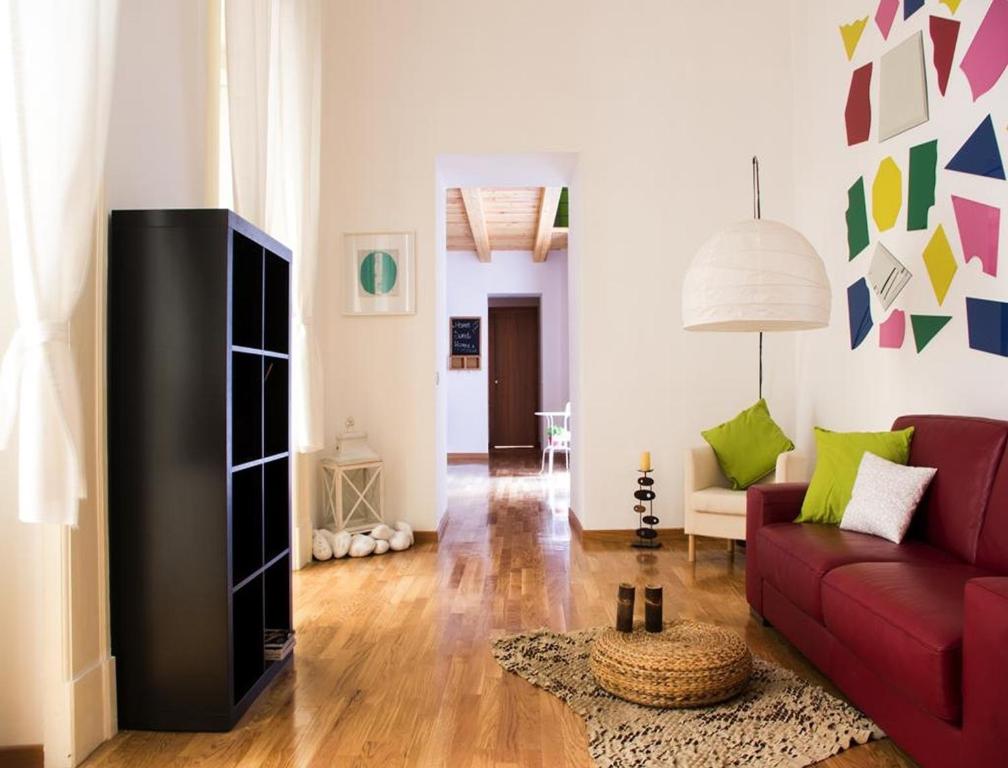 ein Wohnzimmer mit einem roten Sofa und einem TV in der Unterkunft Residenza Principe di Carafa in Neapel