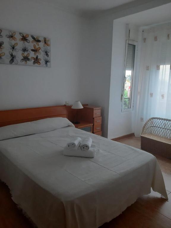a bedroom with a bed with two towels on it at Apartamento Sagunto frente a Renfe in Sagunto