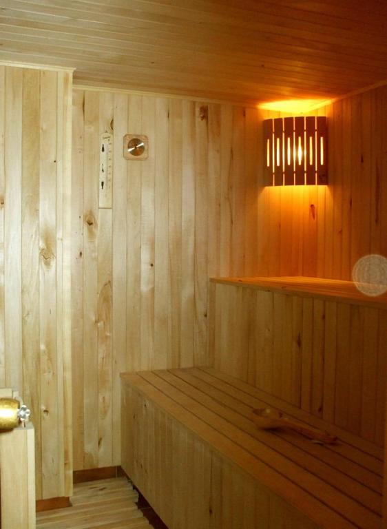 a wooden sauna with a wooden bench in a room at Kotedzas Melnrageje in Klaipėda