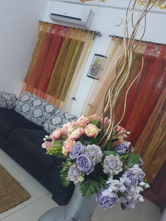 a living room with a couch and a bouquet of flowers at Globe-trotter vision B in Cotonou