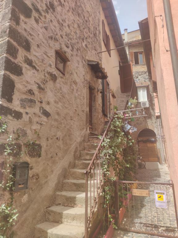 un antiguo edificio de piedra con escaleras junto a un edificio en civico 37, en Trevignano Romano
