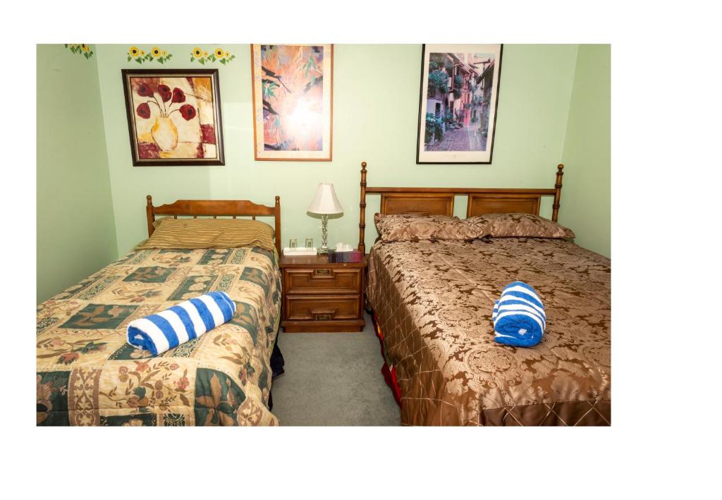 a bedroom with two beds and a table with a lamp at Bed & Breakfast-2 Beds-3 people In Hide-out Private Hidden Bedroom in Abbotsford