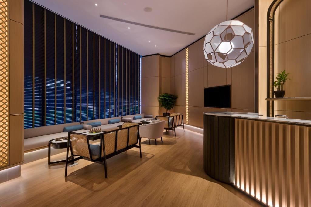 A polished lobby lounge with a reception bar, built-in seating and a large window wall.