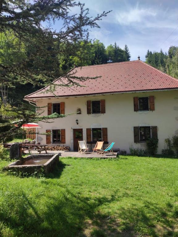 Cette grande maison blanche dispose d'une cour avec des chaises. dans l'établissement chalet Saint Joseph au coeur du massif de la Chartreuse !, à Saint-Christophe-sur-Guiers