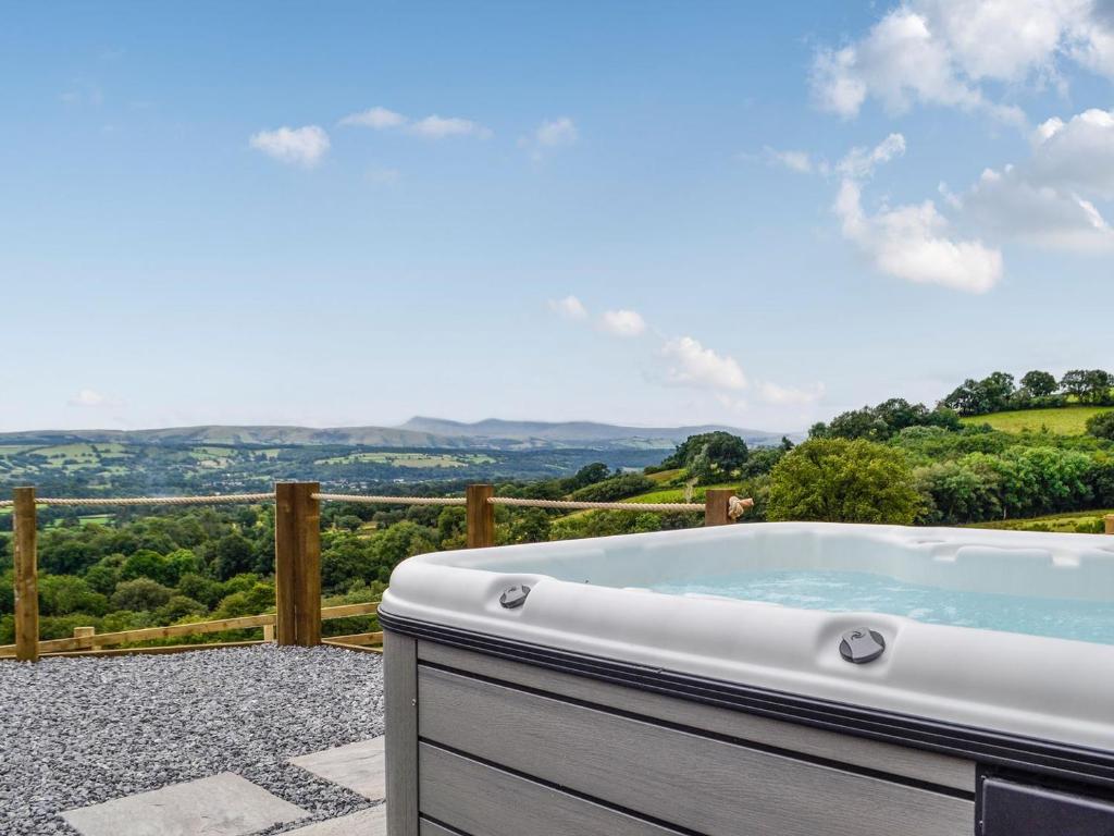 a jacuzzi tub on a patio with a view at Valley View - Uk34178 in Cilycwm